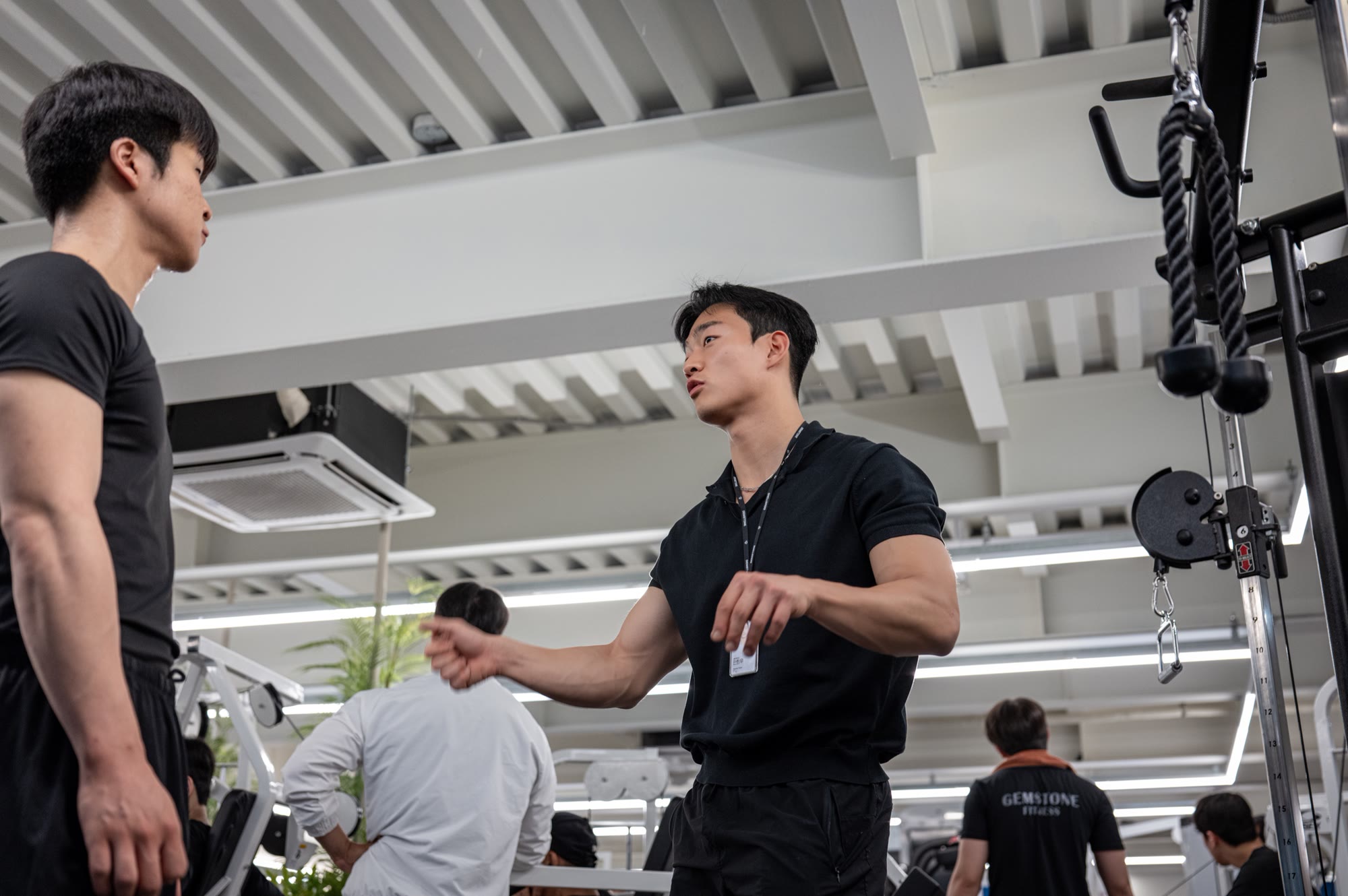 트레이너가 회원에게 운동 방향을 설명하는 장면