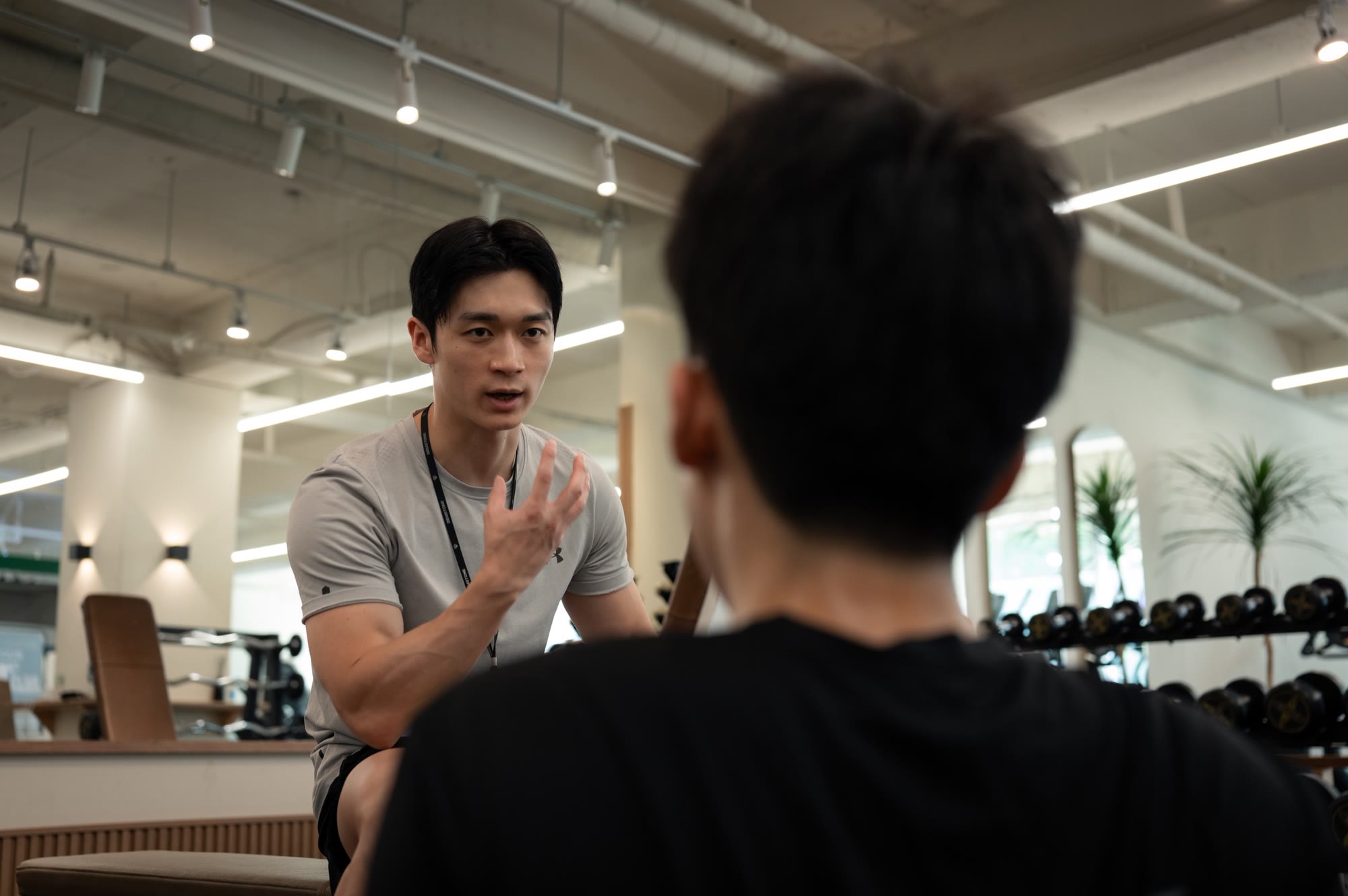 트레이너가 회원과 마주 앉아 수업 방향을 설명하는 장면